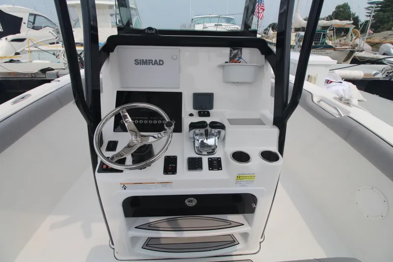 Slide: The Image of 2020 Sea Pro 259 Center Console boat dashboard with steering wheel and controls. - 18
