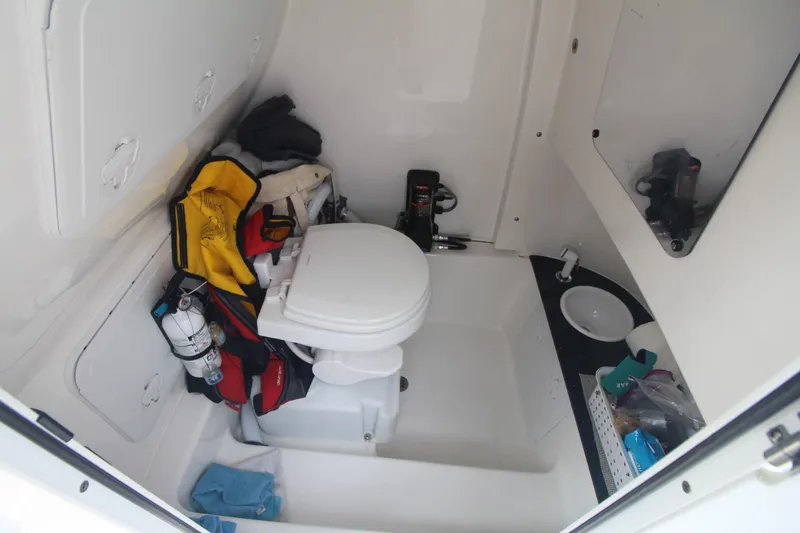 Slide: The Image of 2020 Sea Pro 259 Center Console boat interior with toilet and storage area. - 33