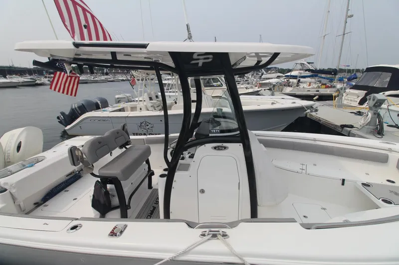 Slide: The Image of 2020 Sea Pro 259 Center Console boat docked at marina with American flags. - 5