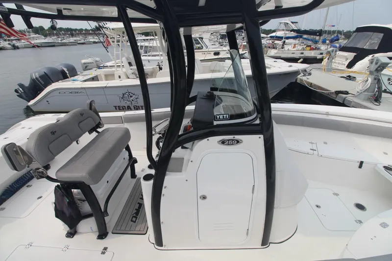 Slide: The Image of 2020 Sea Pro 259 Center Console boat docked at marina, featuring spacious seating and modern design. - 6