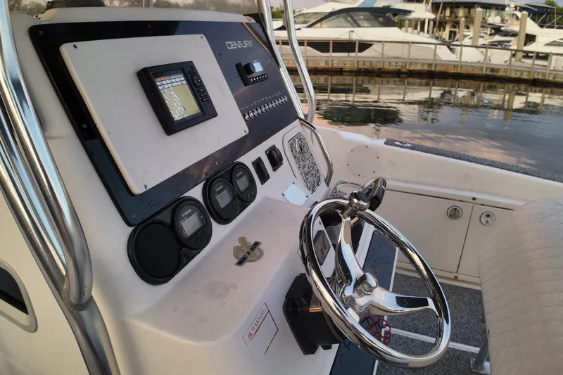 Slide: The Image of 2004 Century 2900 Center Console boat dashboard with steering wheel and navigation controls. - 11
