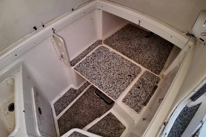 Slide: The Image of 2004 Century 2900 Center Console boat interior with storage compartments and non-slip flooring. - 17