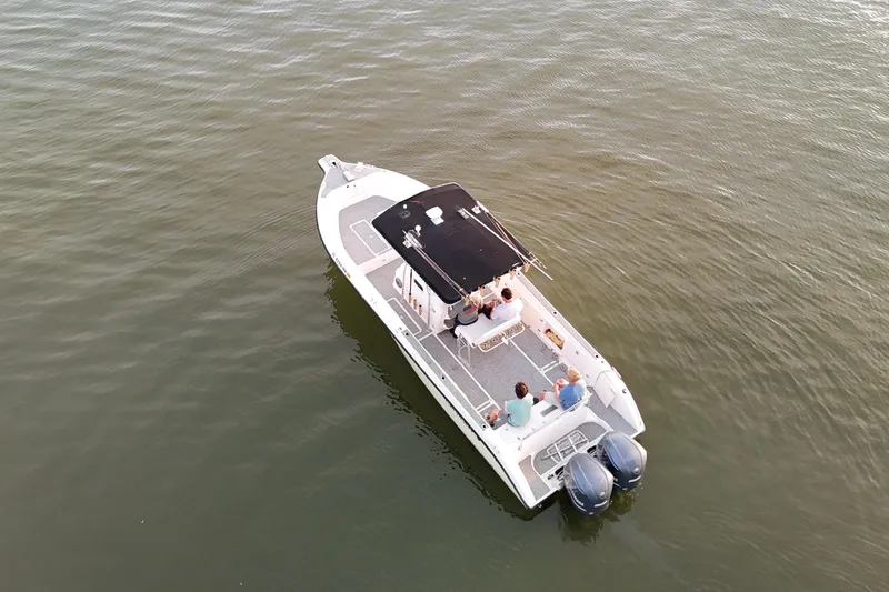 Slide: The Image of 2004 Century 2900 Center Console boat on calm water with passengers, scenic background. - 4