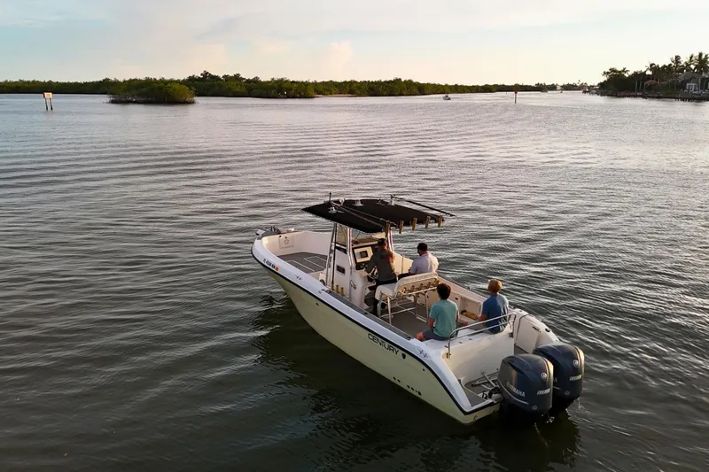 Slide: The Image of 2004 Century 2900 Center Console boat cruising on calm waters at sunset. - 5