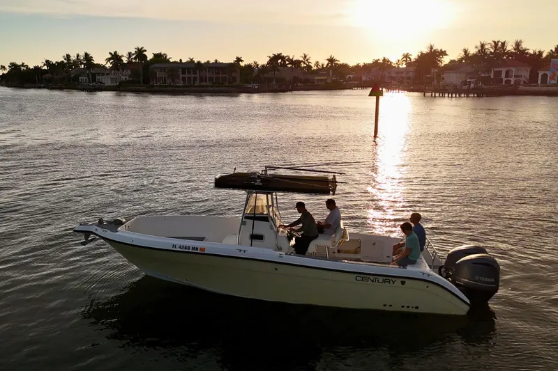 Slide: The Image of 2004 Century 2900 Center Console boat cruising at sunset with passengers onboard. - 7