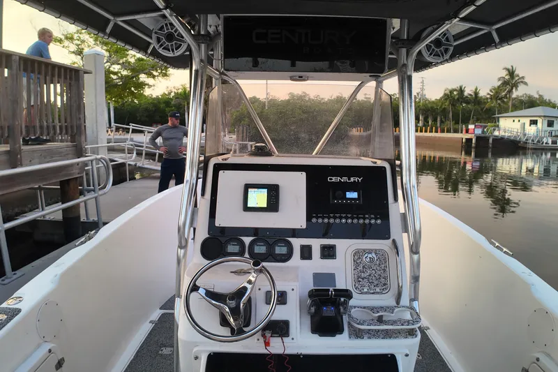 Slide: The Image of 2004 Century 2900 Center Console boat interior with steering wheel and control panel at dock. - 9