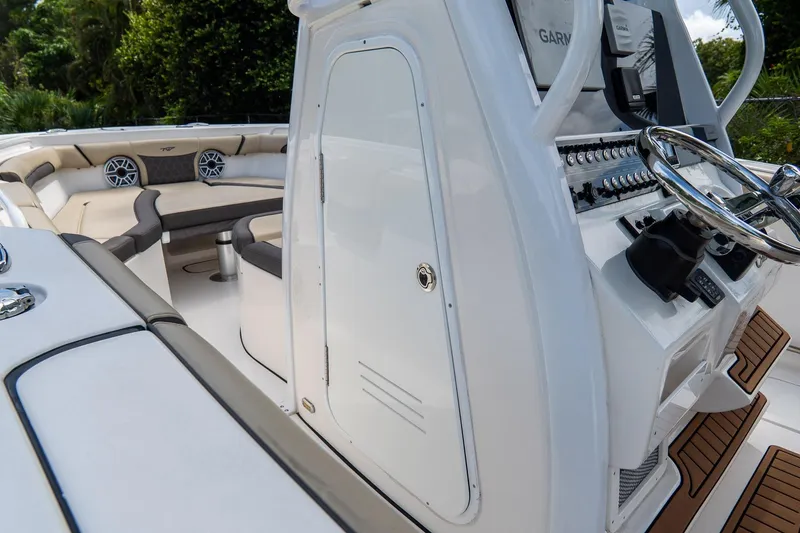 Slide: The Image of 2020 Tidewater 272 CC Adventure boat interior with helm and seating area. - 12