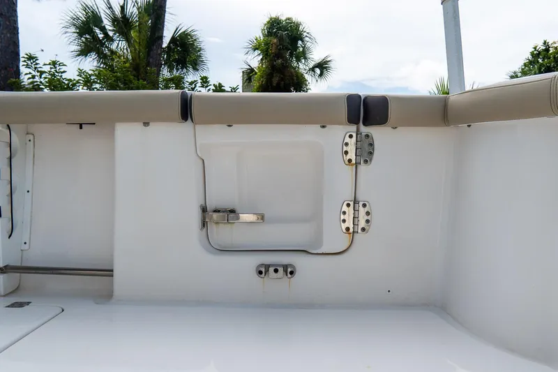 Slide: The Image of 2020 Tidewater 272 CC Adventure boat interior with cushioned seating and storage compartment. - 14
