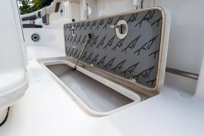 Slide: The Image of 2020 Tidewater 272 CC Adventure boat storage compartment with open hatch and sleek design. - 24