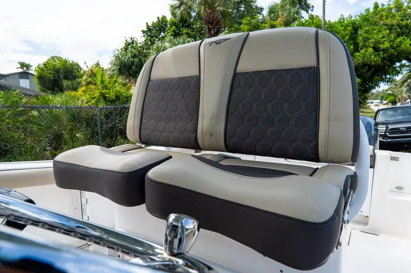 Slide: The Image of 2020 Tidewater 272 CC Adventure boat seats with hexagonal stitching, surrounded by lush greenery. - 33
