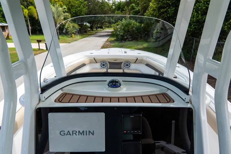 Slide: The Image of 2020 Tidewater 272 CC Adventure boat with Garmin navigation system, docked on a scenic road. - 35