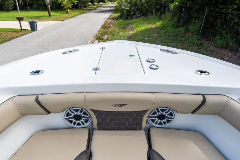 Slide: The Image of 2020 Tidewater 272 CC Adventure boat interior with cushioned seating and speakers. - 44