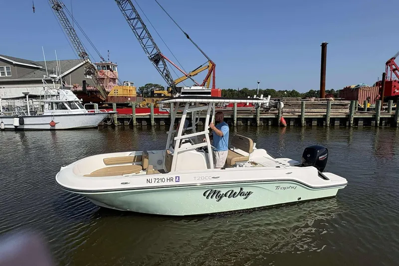 Slide: The Image of 2022 Bayliner Trophy T20CC boat docked near cranes and industrial area. - 10
