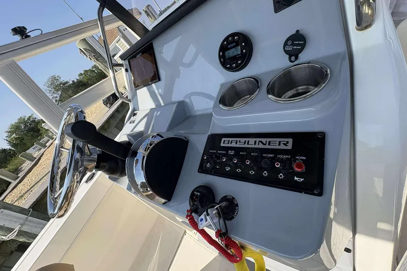 Slide: The Image of 2022 Bayliner Trophy T20CC boat dashboard with steering wheel and control panel. - 14