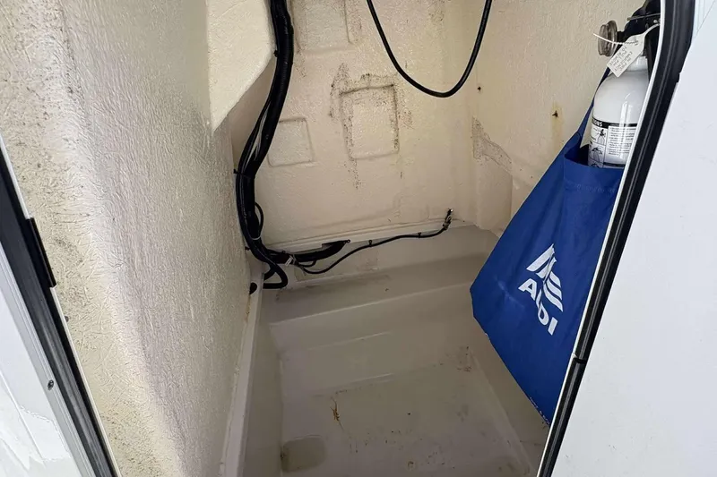 Slide: The Image of 2022 Bayliner Trophy T20CC storage compartment with cables and a fire extinguisher. - 16
