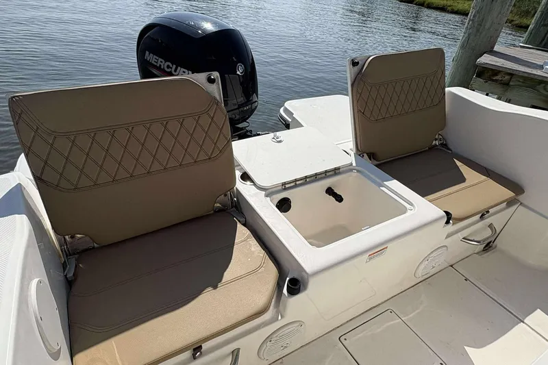 Slide: The Image of 2022 Bayliner Trophy T20CC boat interior with seating and storage, featuring a Mercury engine. - 17