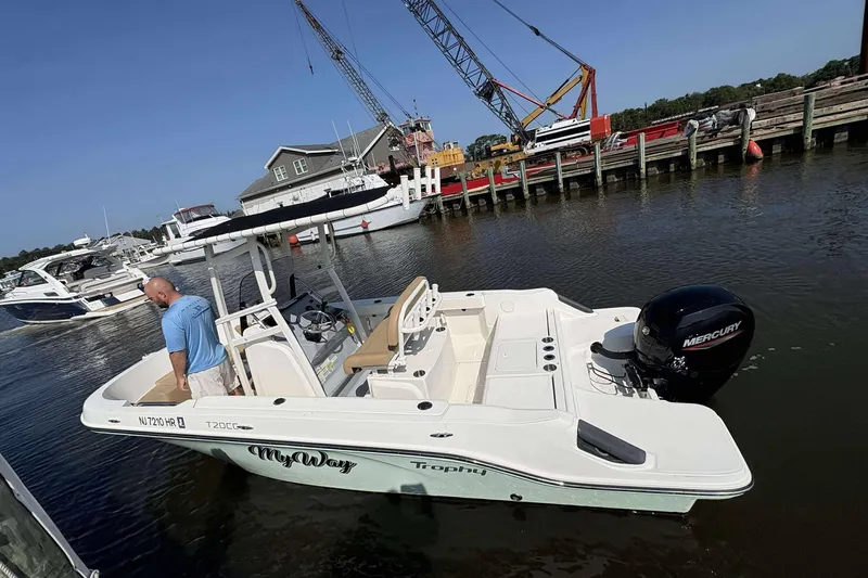 Slide: The Image of 2022 Bayliner Trophy T20CC boat docked, featuring a Mercury engine, with a person onboard. - 9