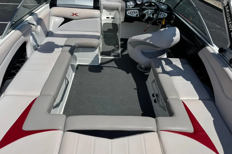 Slide: The Image of 2007 MasterCraft X15 boat interior with white and red seating, modern dashboard, and spacious layout. - 13