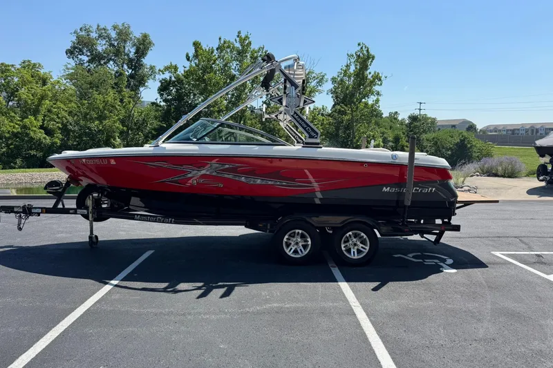Slide: The Image of 2007 MasterCraft X15 boat in red and black on a trailer, parked outdoors. - 7