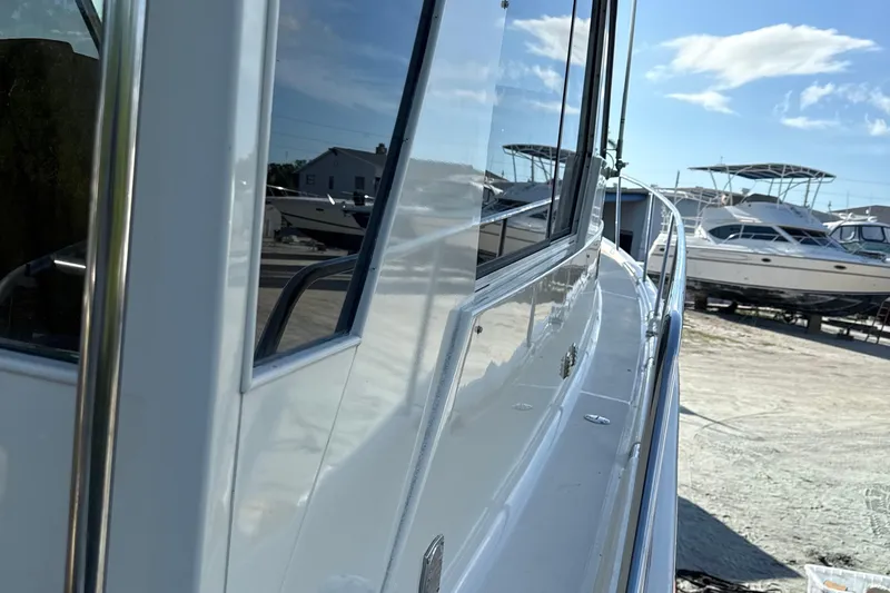 Slide: The Image of 2008 Mainship Pilot 34 boat side view in a sunny marina setting. - 11