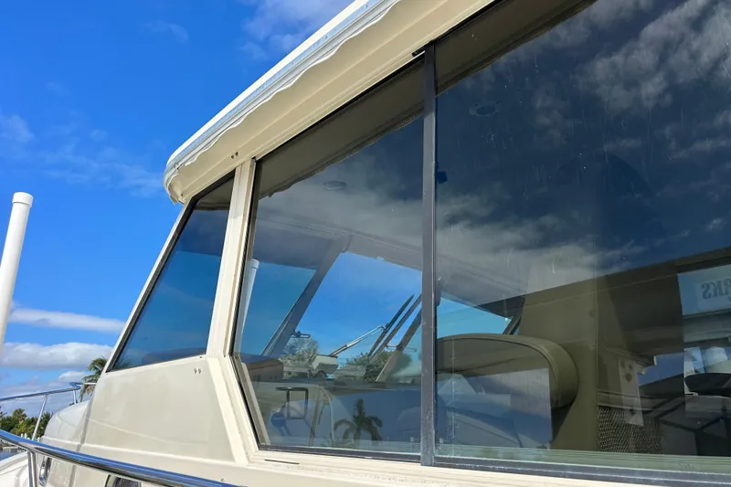 Slide: The Image of 2008 Mainship Pilot 34 boat deck with anchor chain and hatch, docked on calm water. - 25