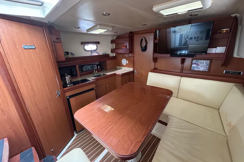 Slide: The Image of 2008 Mainship Pilot 34 interior with wood finish, kitchenette, and seating area. - 45
