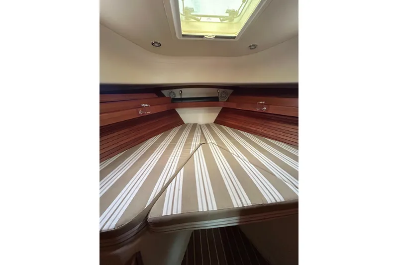 Slide: The Image of 2008 Mainship Pilot 34 cabin interior with striped bedding and wooden accents. - 46