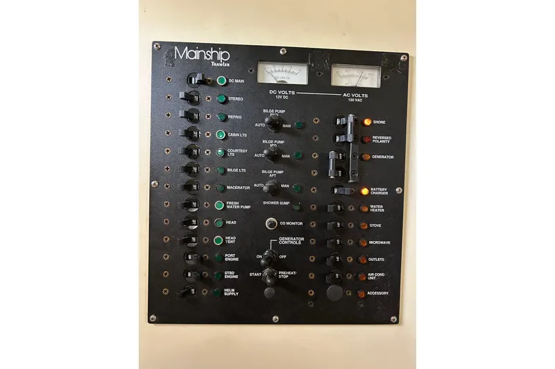 Slide: The Image of Electrical control panel of a 2008 Mainship Pilot 34 boat, featuring various switches and indicators. - 49