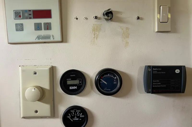 Slide: The Image of Control panel of a 2008 Mainship Pilot 34 boat with various gauges and switches. - 52