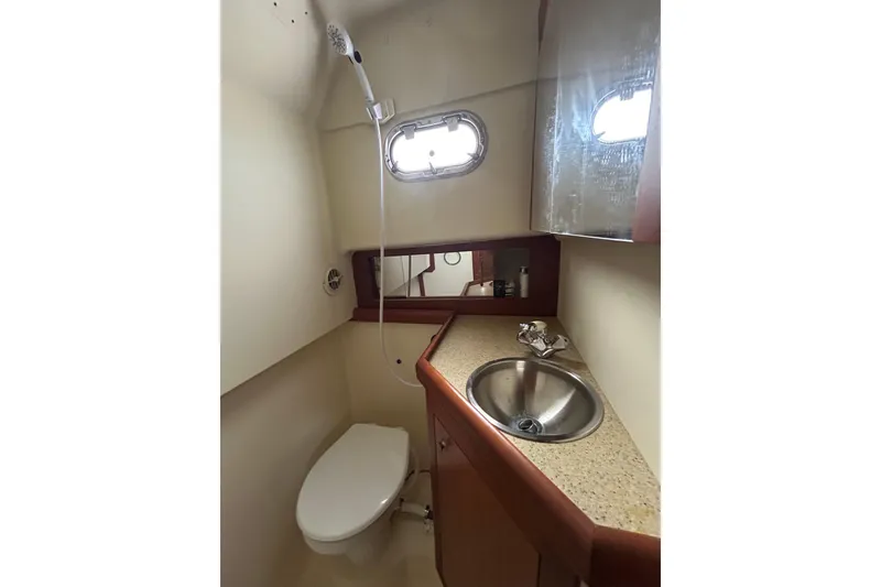 Slide: The Image of 2008 Mainship Pilot 34 boat bathroom with sink, toilet, and showerhead. - 53