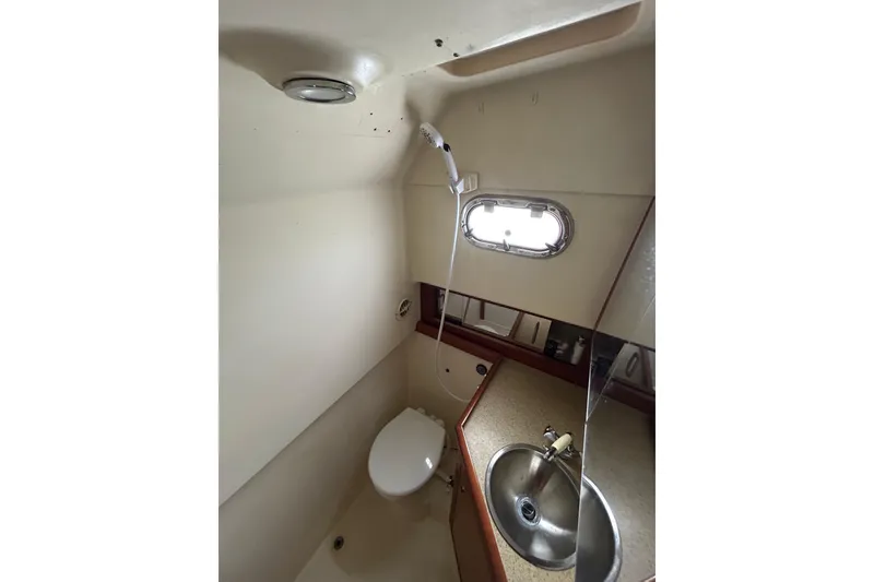 Slide: The Image of 2008 Mainship Pilot 34 boat bathroom with sink, toilet, and showerhead. - 54