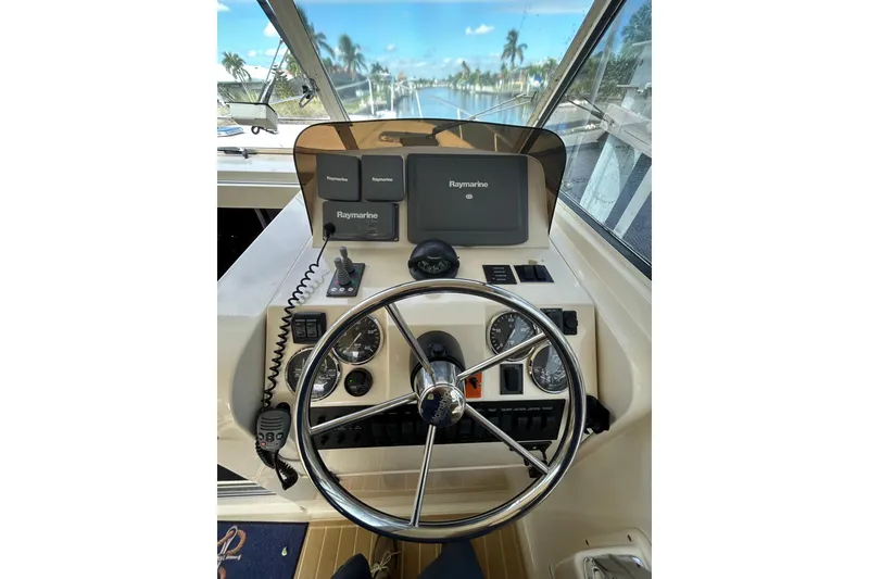 Slide: The Image of 2008 Mainship Pilot 34 helm with steering wheel and navigation controls. - 58