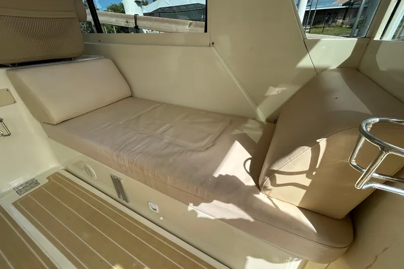 Slide: The Image of 2008 Mainship Pilot 34 interior with beige seating and cup holders, showcasing comfort and style. - 69