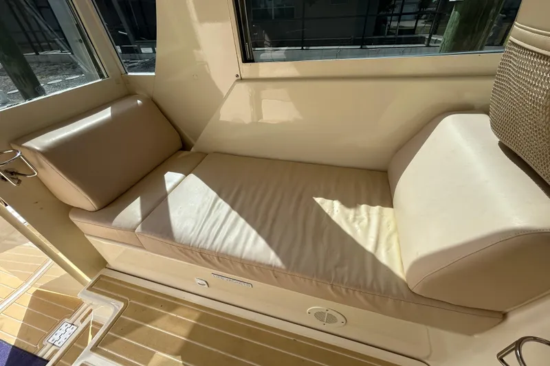 Slide: The Image of 2008 Mainship Pilot 34 interior seating area with beige cushions and wooden flooring. - 70