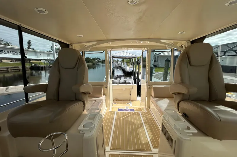 Slide: The Image of 2008 Mainship Pilot 34 interior with beige seating and wooden flooring. - 72