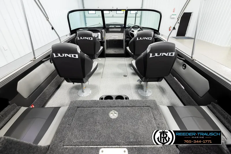 Slide: The Image of 2026 Lund 1875 Tyee boat interior with four seats, branded "Lund," in a showroom. - 12