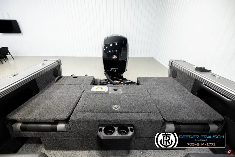 Slide: The Image of 2026 Lund 1875 Tyee boat interior with motor, carpeted deck, and storage compartments. - 20