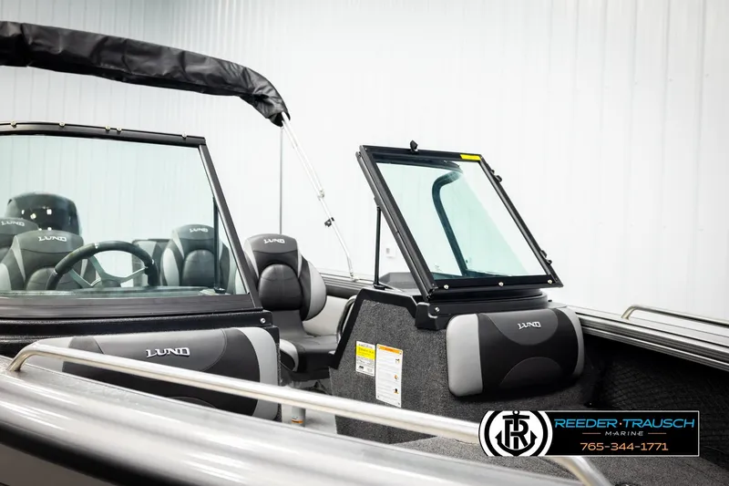 Slide: The Image of 2026 Lund 1875 Tyee boat interior with seating and steering wheel, displayed at Reeder-Trausch Marine. - 31