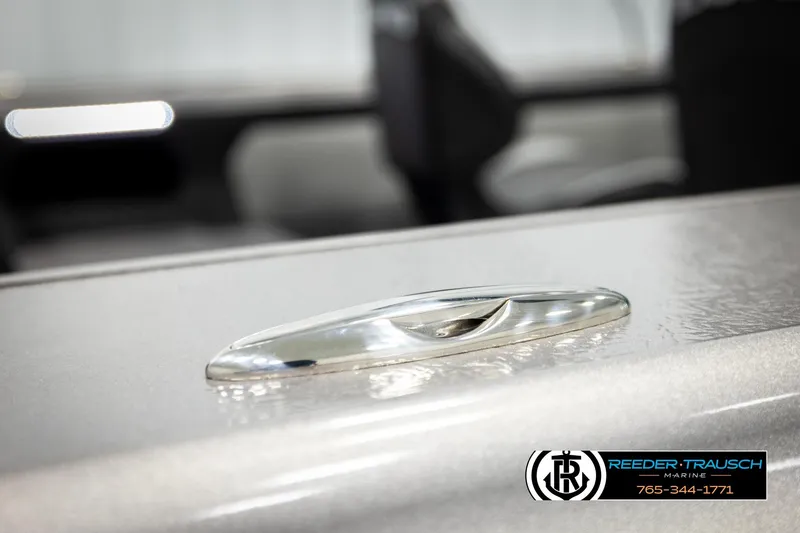Slide: The Image of 2026 Lund 1875 Tyee boat detail with sleek metallic finish, Reeder-Trausch Marine logo visible. - 64
