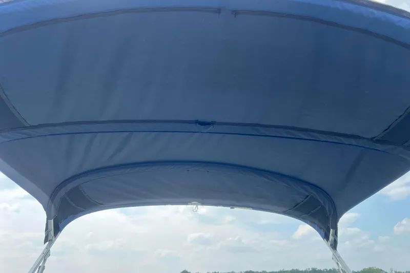 Slide: The Image of Blue canopy of 2019 Ranger Reata 200C boat against a cloudy sky. - 30