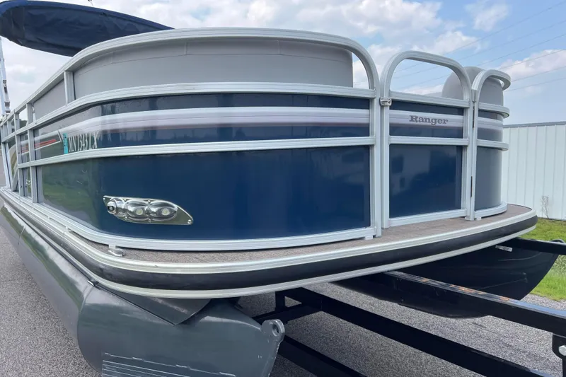 Slide: The Image of 2019 Ranger Reata 200C pontoon boat on trailer, blue and silver design. - 38