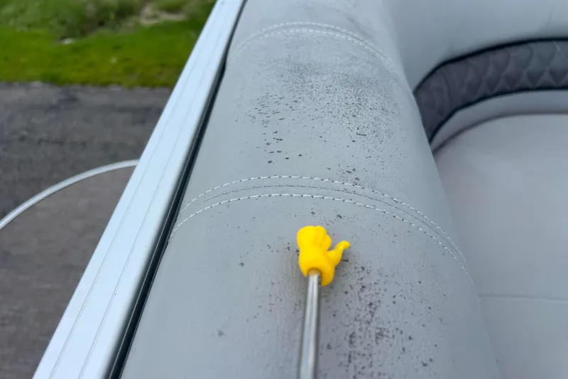 Slide: The Image of Close-up of 2019 Ranger Reata 200C boat seat with yellow tool on gray upholstery. - 47