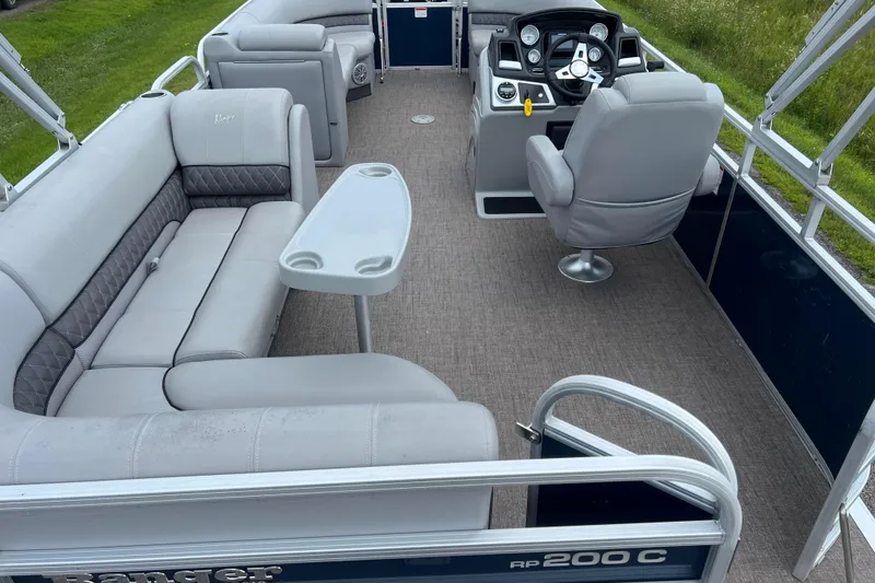 Slide: The Image of 2019 Ranger Reata 200C pontoon boat interior with gray seating and steering console. - 8