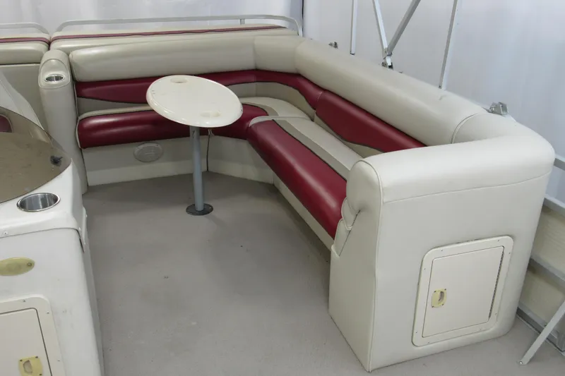 Slide: The Image of 2000 Sylvan Supreme LX boat interior with red and white seating and small table. - 5