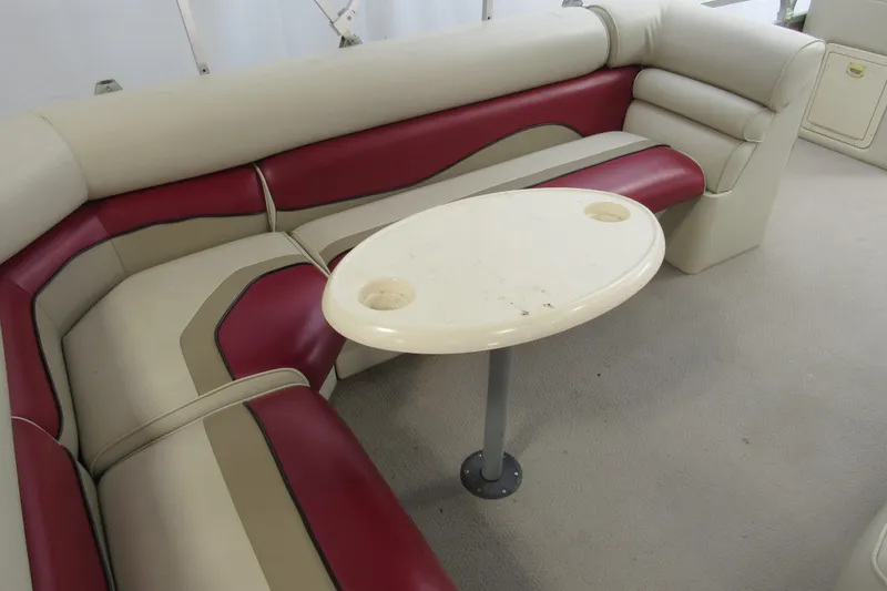 Slide: The Image of 2000 Sylvan Supreme LX boat interior with red and beige seating and oval table. - 8