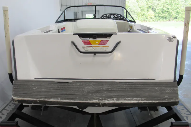 Slide: The Image of 1996 Nautique Ski 196 boat, rear view, white exterior, in a garage setting. - 3