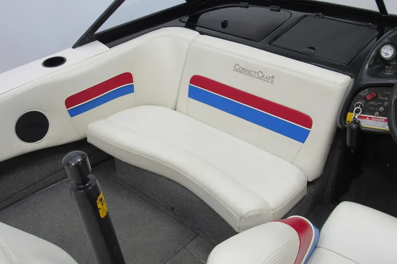 Slide: The Image of 1996 Nautique Ski 196 boat interior with white seats, red and blue accents, and dashboard controls. - 6