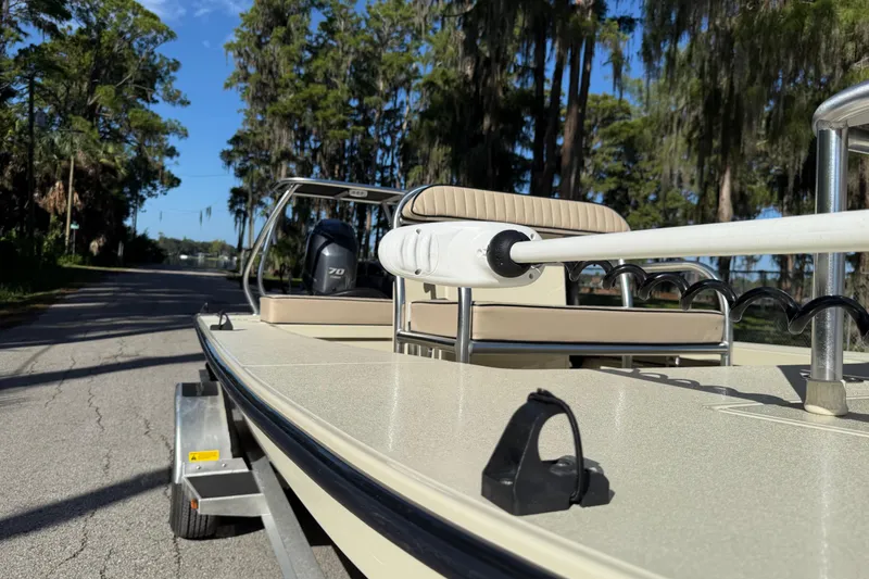 Slide: The Image of 2020 East Cape EVO X 18 boat on trailer, parked on a tree-lined road. - 28