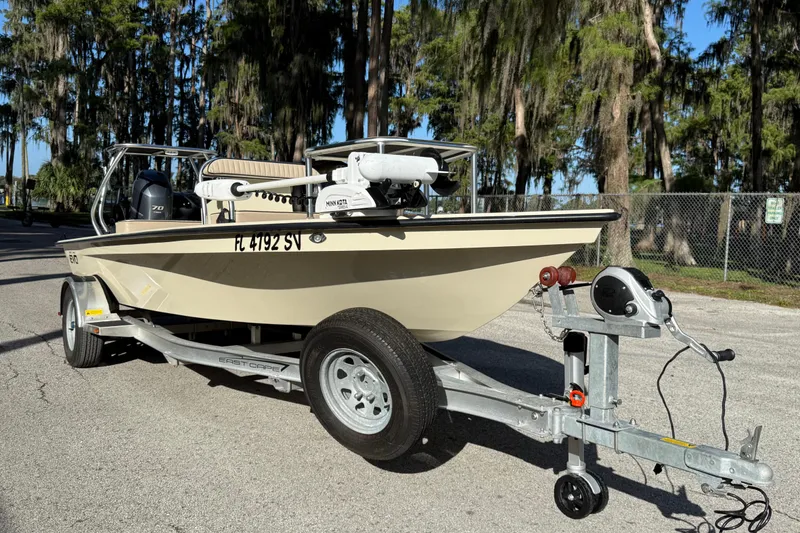 Slide: The Image of 2020 East Cape EVO X 18 boat on trailer, parked outdoors with trees in background. - 3
