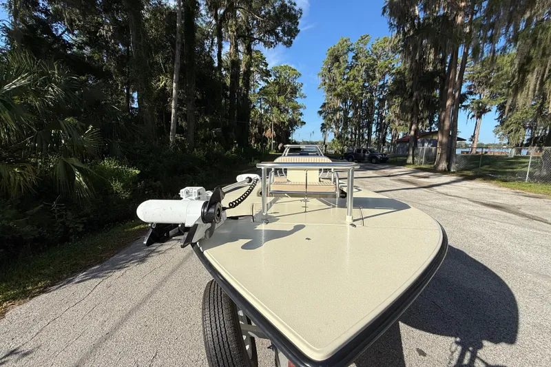 Slide: The Image of 2020 East Cape EVO X 18 boat on trailer, surrounded by trees. - 6